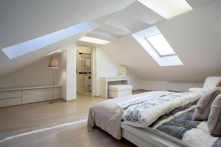 Spacious attic bedroom with sloped ceilings and skylight