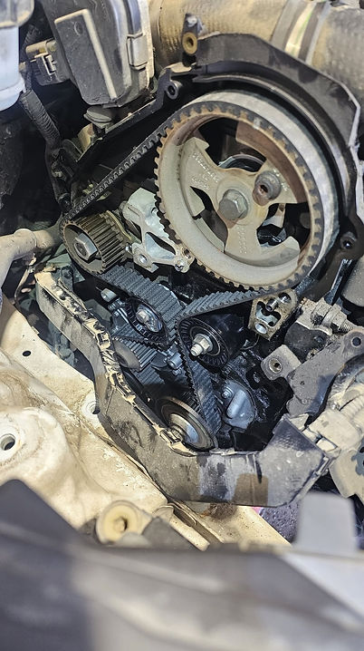 Detailed view of an exposed vehicle engine timing belt with pulleys and gears