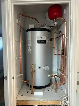 A water heater system enclosed in a small cupboard