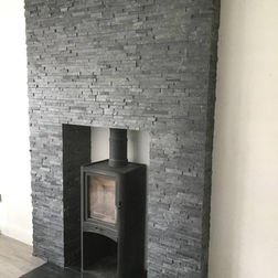 A cozy fireplace featuring a wood-burning stove, surrounded by a rustic mantel and warm ambiance