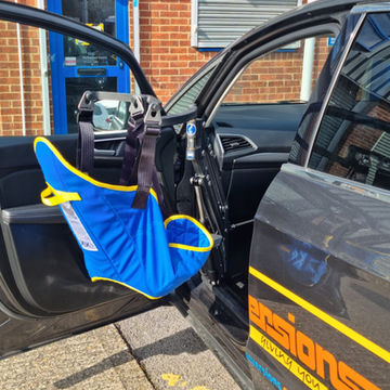 Person using a person lift hoist to transfer from a wheelchair into a car seat