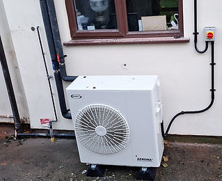 External air source heat pump unit installed on a gravel base
