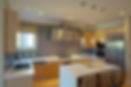 Modern kitchen with light wood cabinets and stainless steel appliances