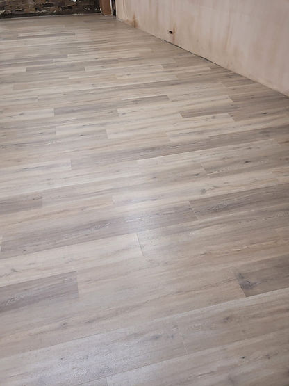Modern grey wood-effect vinyl flooring planks installed in a room