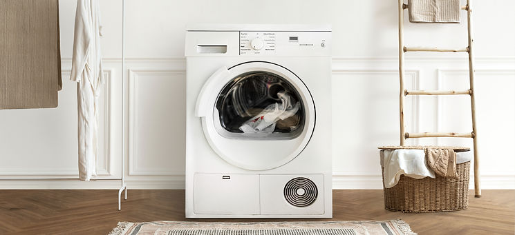 Minimalist laundry setup featuring a white washing machine next to a woven basket and wooden towel ladder
