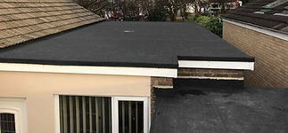 Flat, black-roofed extension with adjacent sloped roofs