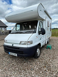 White motorhome parked on a gravel driveway