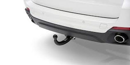 Rear view of a white car with a black tow hitch installed underneath the bumper