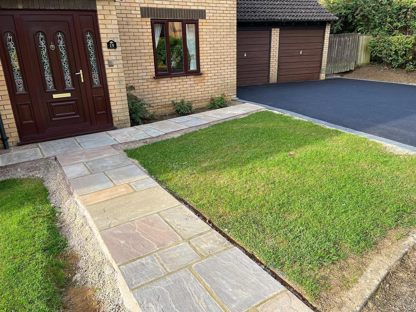 Suburban house with a brick exterior, brown front door, and path