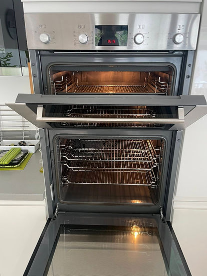 A modern double oven with stainless steel finish, both compartments open