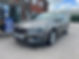 Silver car parked in front of a brick building near an MOT sign