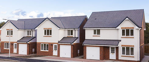 A modern two-story house with a brick and white facade, pitched roof, garage, and four front windows