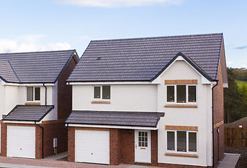 Two modern suburban houses with brick and cream facades, dark grey tiled roofs, and white garage doors under a clear blue sky