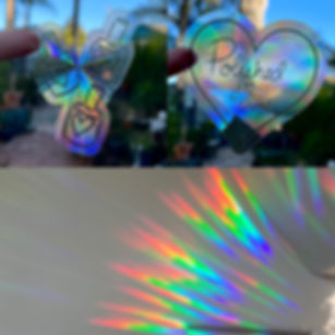Iridescent nail polish and heart suncatcher stickers, rainbow light on wall showing effect of them in the sun. 