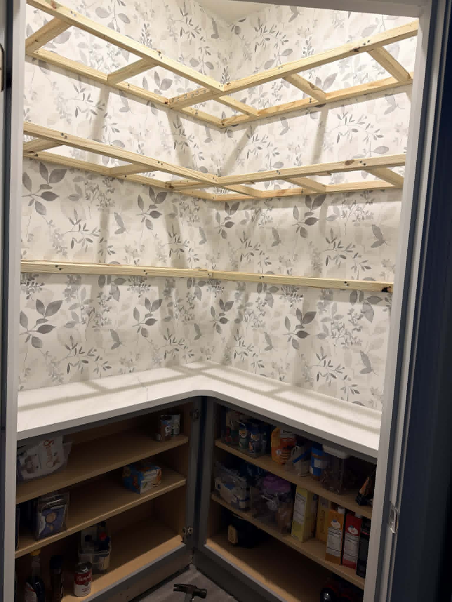 Wallpaper hung, shelf frames going up