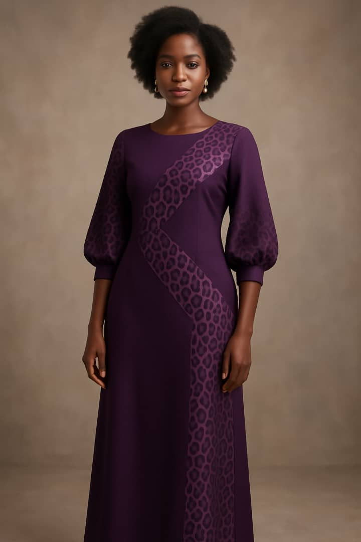 Femme vêtue d'une robe violette avec des motifs, tinob creation dans les détails.