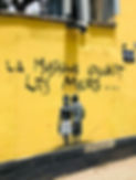 Mur jaune avec graffiti "La musique adoucit les murs" — illustration symbolique du lien entre art et thérapie Gestalt.