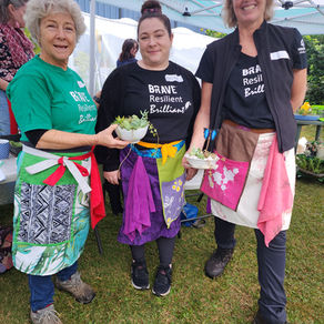 Three GROW Volunteers with their succulent bowls and colourful handmade garden aprons