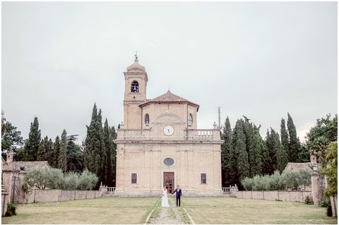 un couple de mariés devant une église en italie