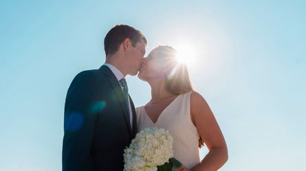 un couple s'embrasse devant un grand ciel bleu