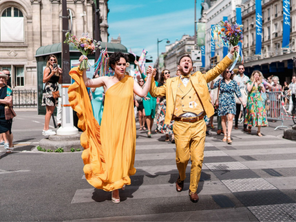 des mariés habillés en jaune sortent heureux de la mairie