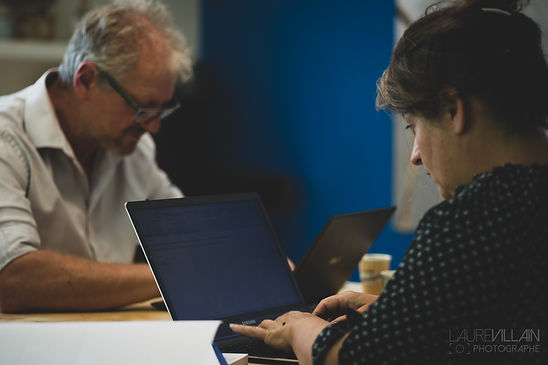 Photo de 2 personnes travaillant. Au premier plan une femme, au second plan un homme. Photo prise par Laure VILLAIN