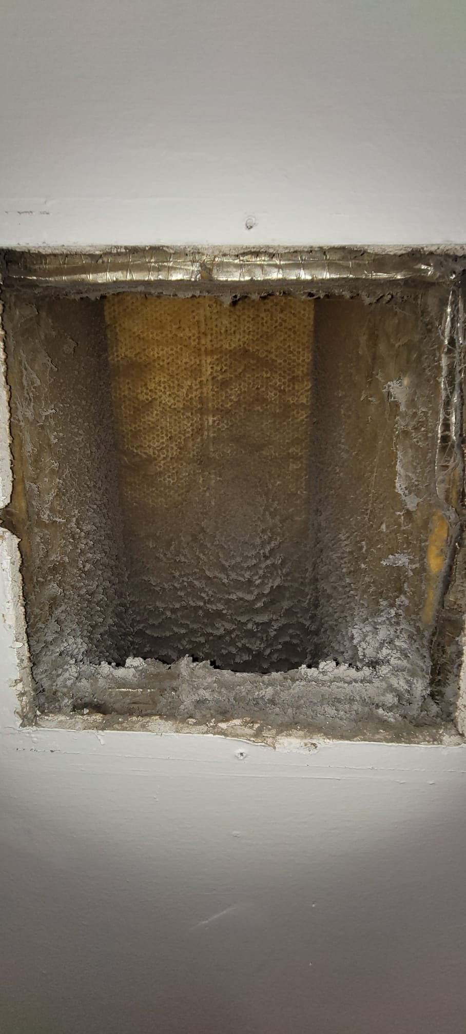 Air duct obstructed by debris in Mamaroneck before cleaning.
