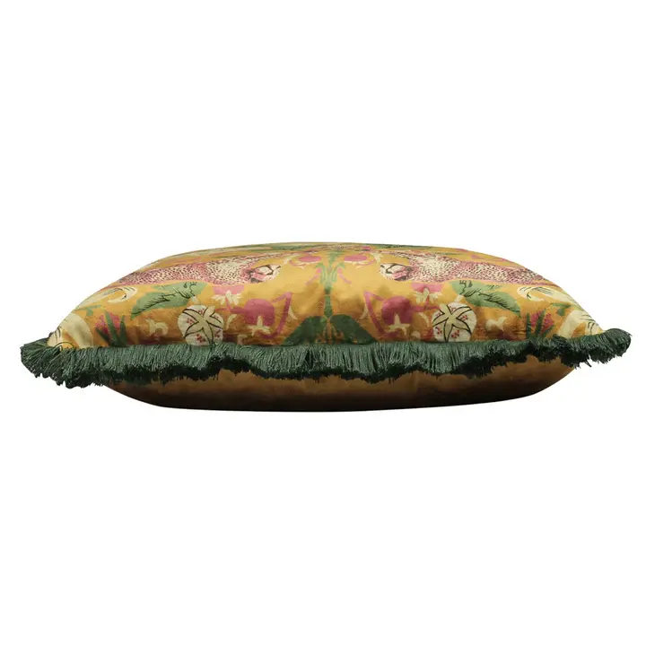 Thumbnail: Mustard tropical print cushion with colourful floral design and green fringe trim, styled on a dark chair.