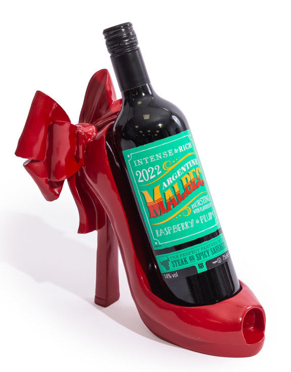 Glossy red stiletto high heel bottle holder with large ribbon bow, quirky statement home bar decor.