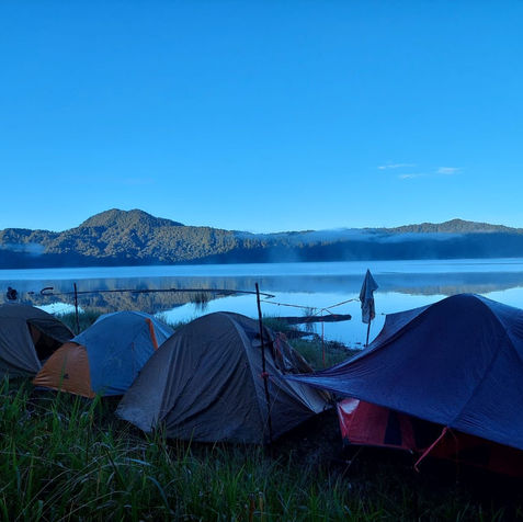 Campsite at serene lake, majestic mountains