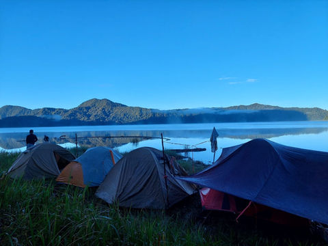 Campsite at serene lake, majestic mountains