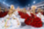 Parade of dancers in red, white costumes adorned with gold and feathers, vibrant streamers. Nighttime carnival, grandstands full of spectators.