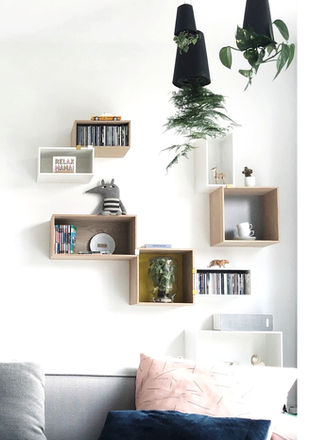 Wit en licht houten wandkastjes, willekeurig geplaatst voor een dynamische en speelse wand.