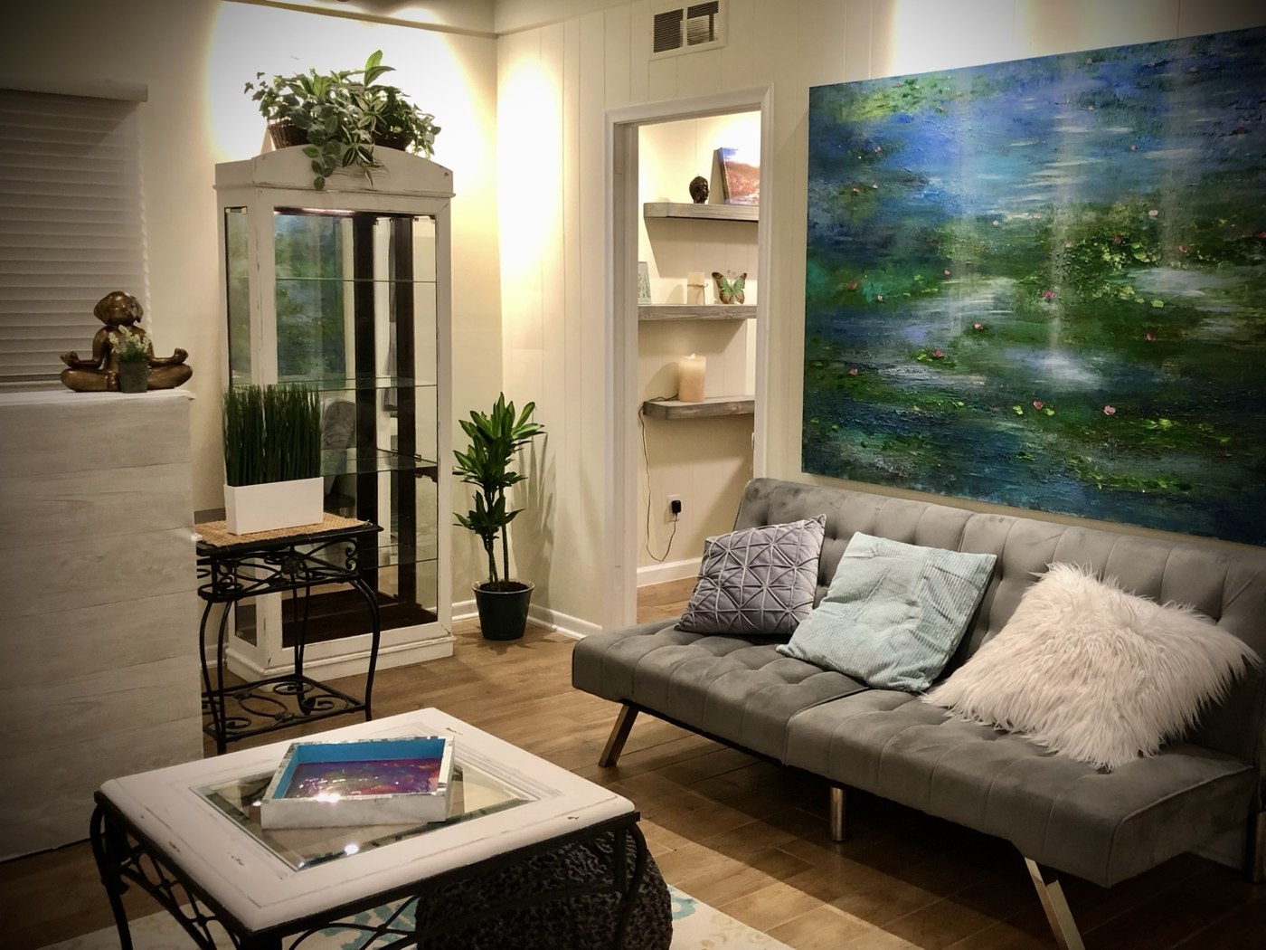 A welcoming sitting area at The Drake Center with original blue-green art and plants