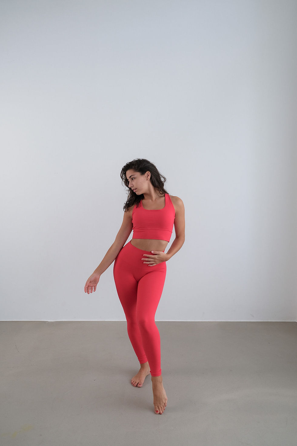 woman wearing The Nourished Club strappy sports bra in red, front view
