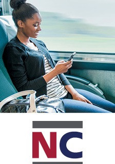 Woman sitting on a train texting on her phone. NC by train logo is placed under the image.