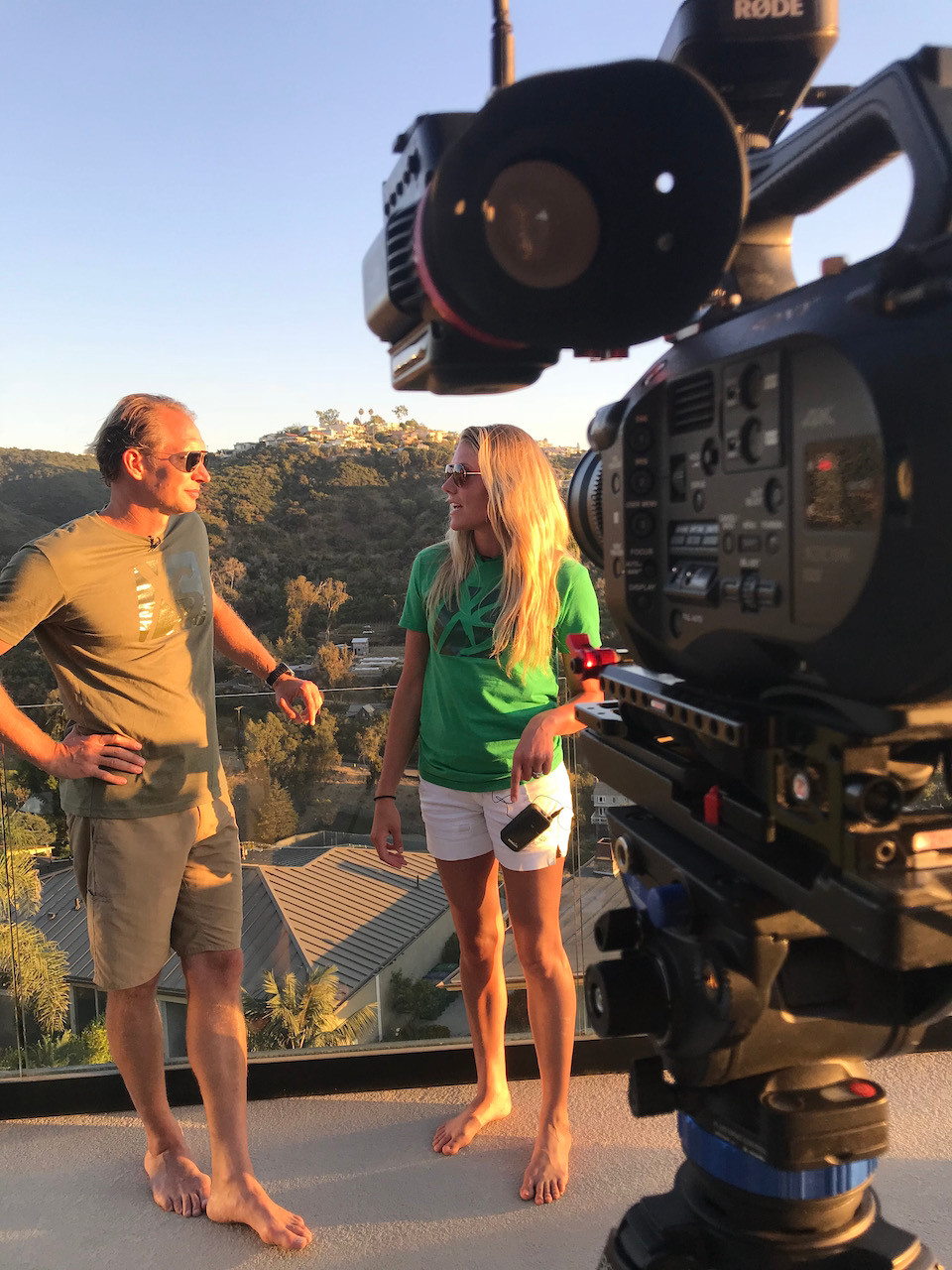 Behind the scenes 20EVO video corporate film shoot. Photo taken behind a Sony cinema camera setup on a balcony overlooking a canyon in Laguna Beach, CA
