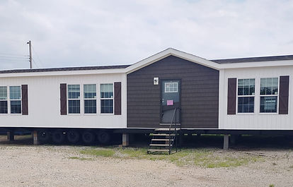 Front exterior of the Anniversary manufactured home with gray siding, white trim, a gabled roof, and large floor-to-ceiling windows, available now at Oxford Housing Inc. in Alabama.