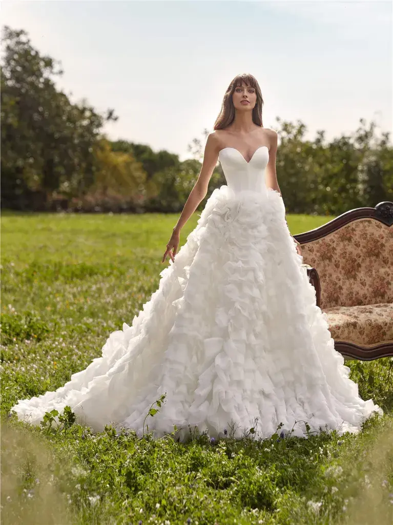 Vestido de noiva Nicole Milano disponível na Templo Fashion, modelagem princesa com corpete estruturado, decote em coração e saia volumosa em camadas de tecidos texturizados, criando uma silhueta marcante e elegante.