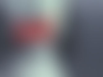 Close-up of a pale face with red tape over the mouth, dark hair, and a gray moody background, suggesting silence or censorship.