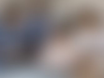 A woman sat in a hospital bed, surrounded by healthcare workers. All the workers are leaning in to listen.