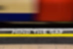 Image showing the 'mind the gap' sign between the yellow line and the edge of the platform. Behind is a blurred train.