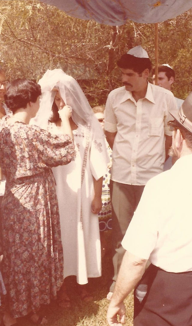 Bride's sister gives the bride wine under wedding canopy. Writer's own picture