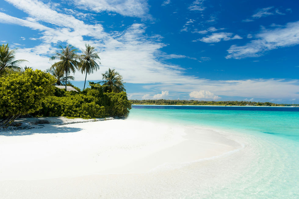 Tropical beach with white sand, turquoise water, palm trees, and a bright blue sky with scattered clouds, calm and sunny