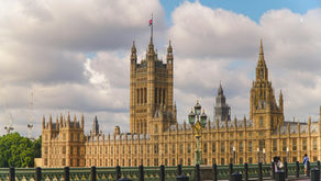 Image of the Houses of Parliament under a cloudy sky.
