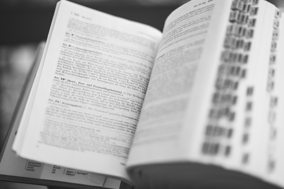 Image of a bulky book, which is open, displaying some text.