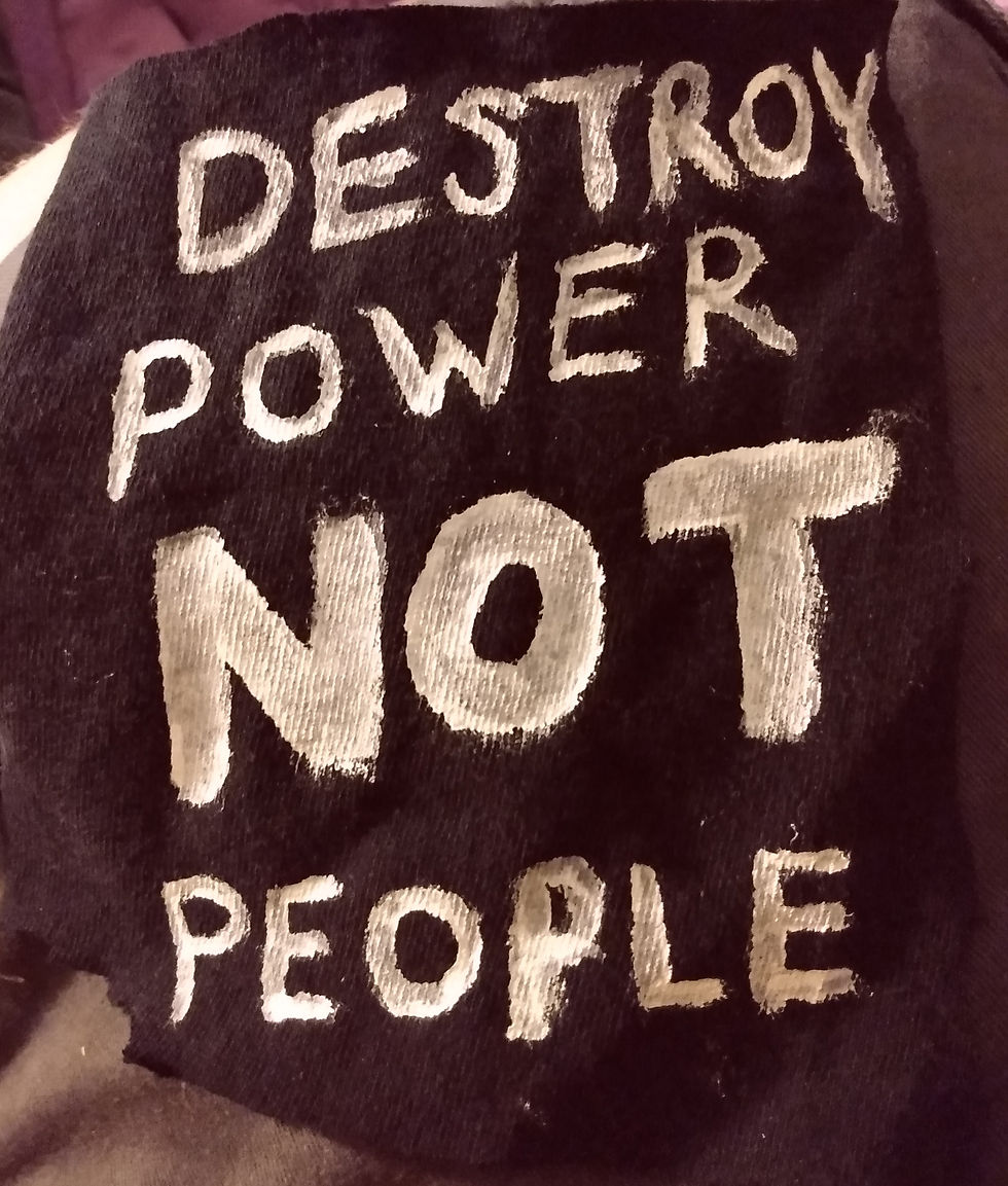 A picture of a handpainted punk patch. It reaads "Destroy Power Not People" in thick white letters on a black canvas background.