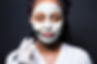 Young beautiful african woman with face mask Spa Skin with a black background