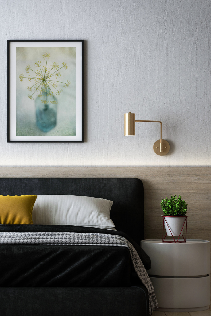 printable wall art above a bedroom with brass light