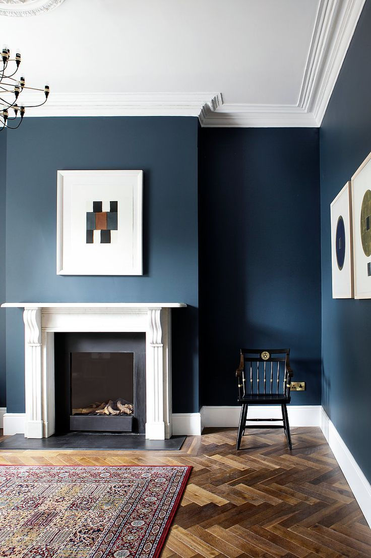 MID CENTURY STYLE LIVING ROOM painted in a deep blue colour with white skirt boards